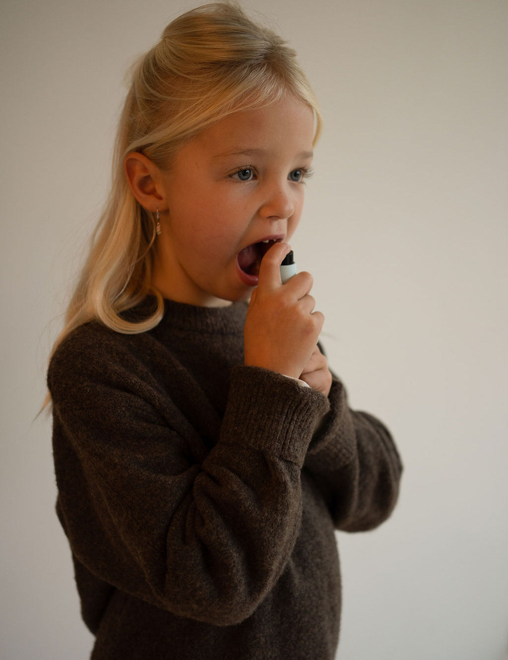 Young-girl-using-kids-pm-vitamin-spray